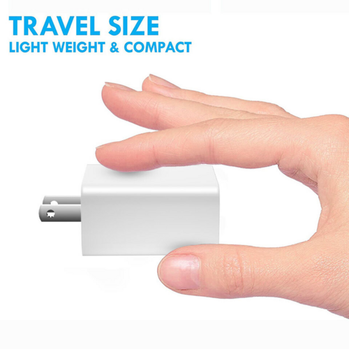 Small white travel adapter held between fingers with 'Travel Size' text above on a white background