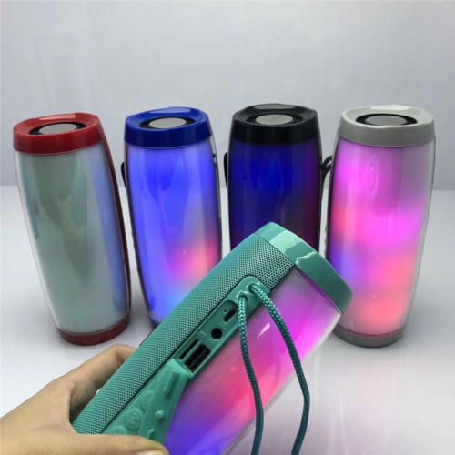 Colorful LED lights with a portable speaker in front on a white background
