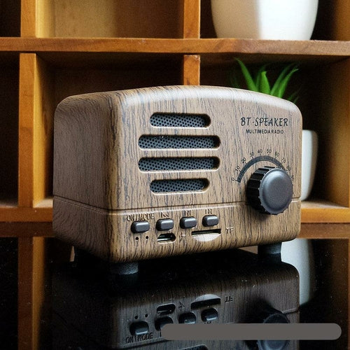 Wooden Bluetooth speaker with vintage design on a wooden shelf.
